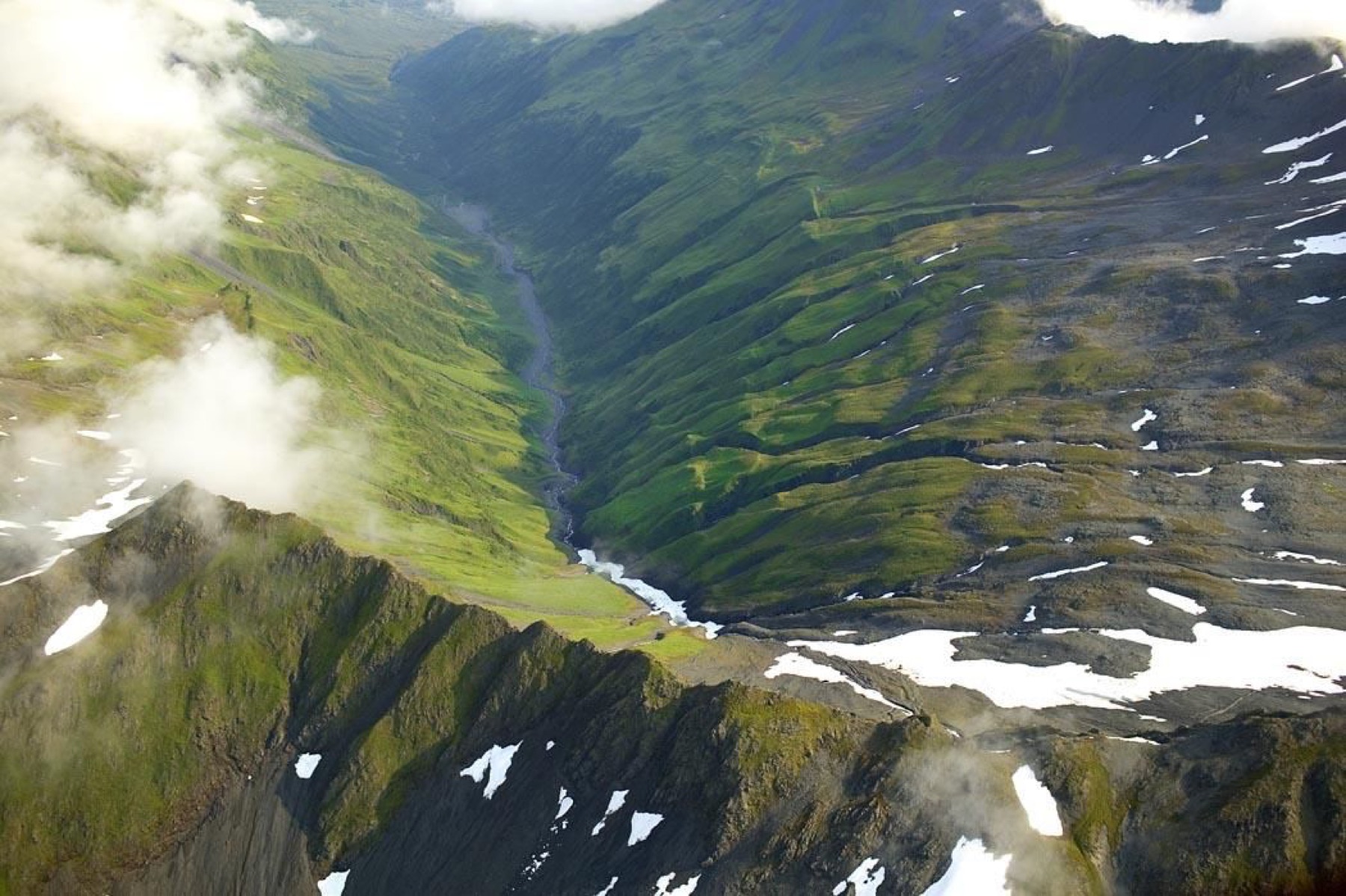 Aerial view of mountain terrain and a river valley.