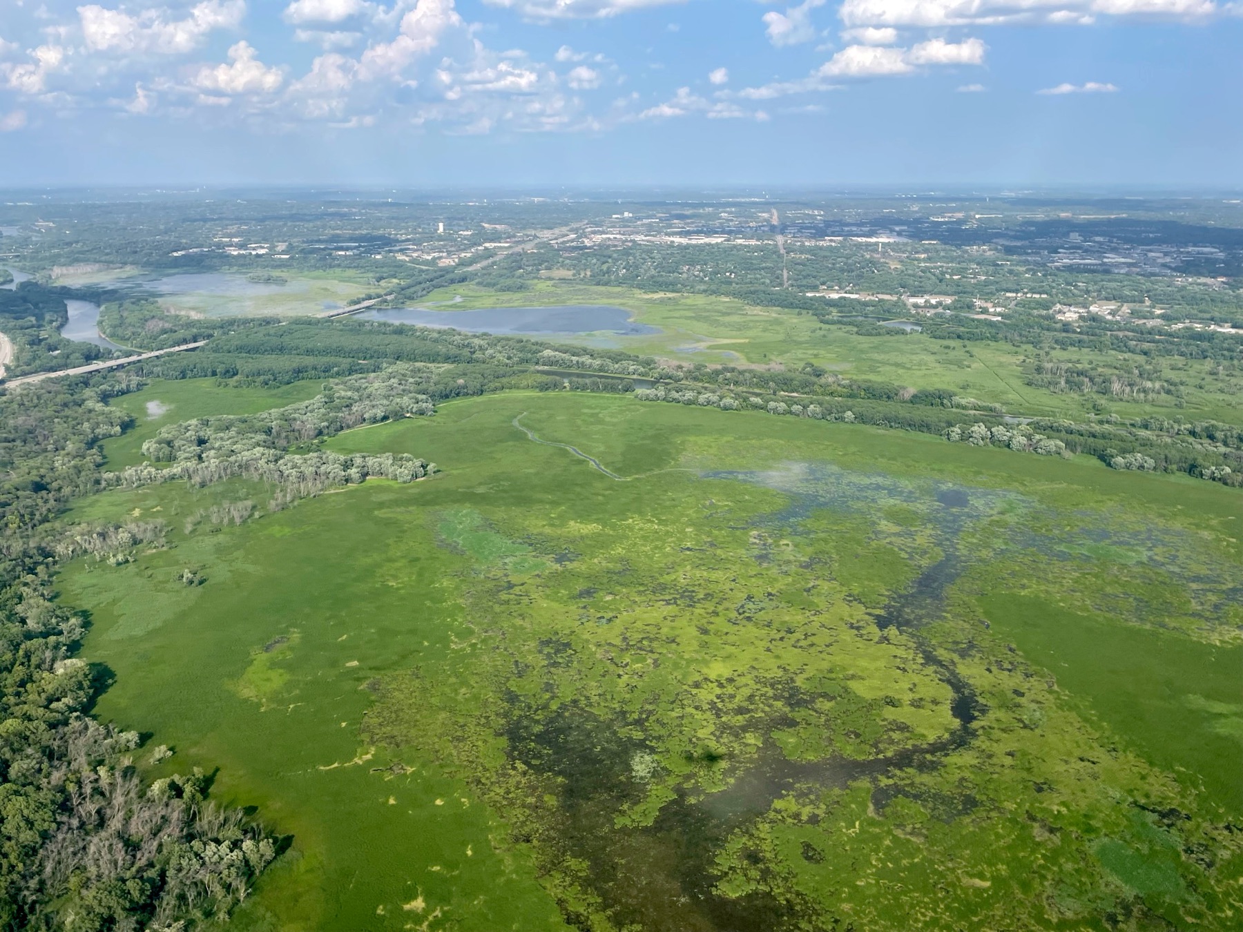 Aerial view of a river valley wetland landscape.