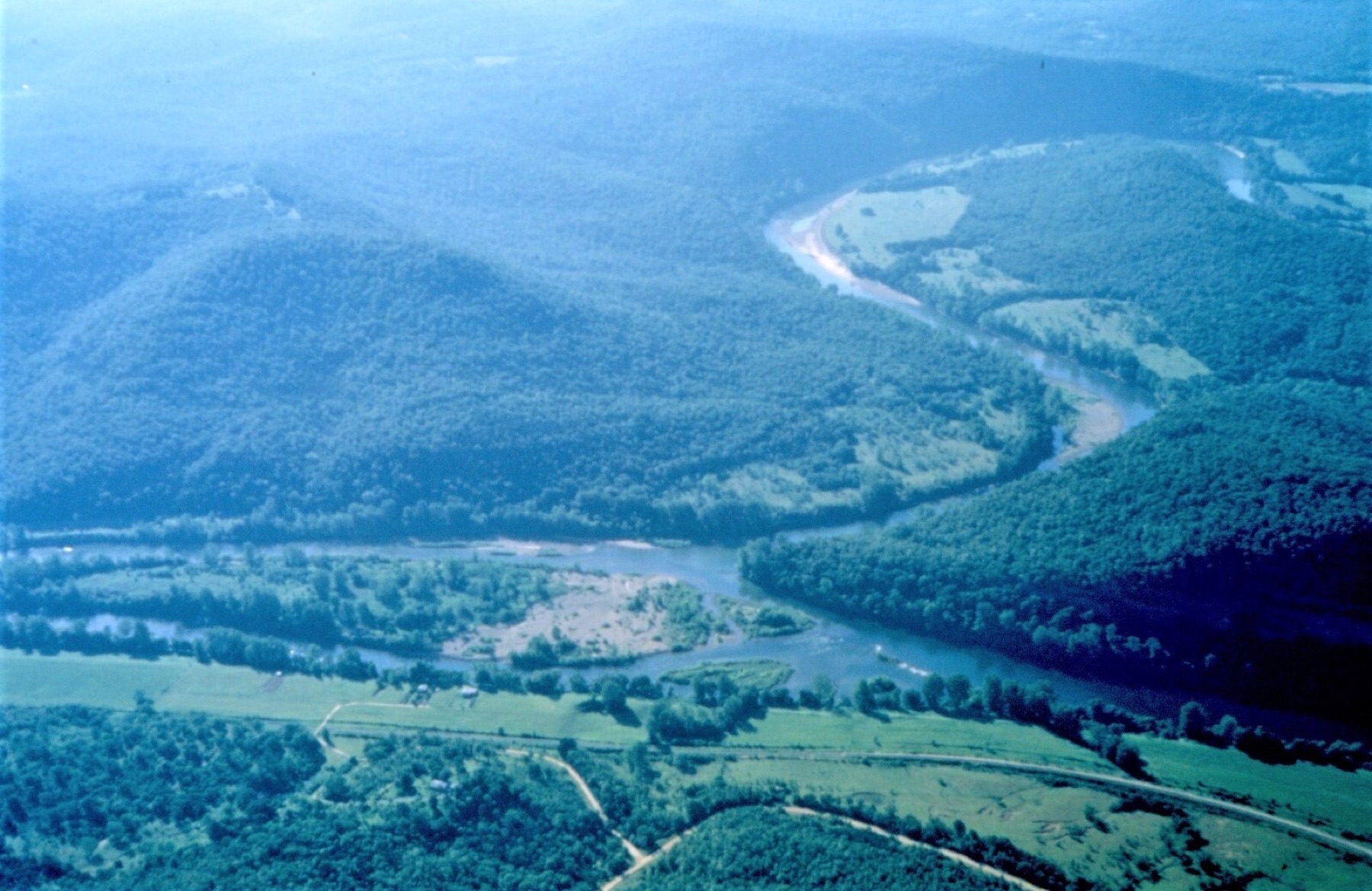 Aerial view of river confluence, floodplain fields, and surrounding land pattern.